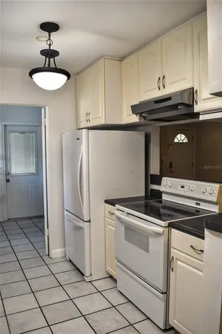 a kitchen with kitchen island a stove cabinets and refrigerator