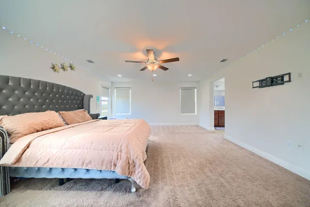 a bedroom with a large bed chandelier and a window