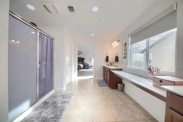 a large bathroom with a large mirror vanity and shower