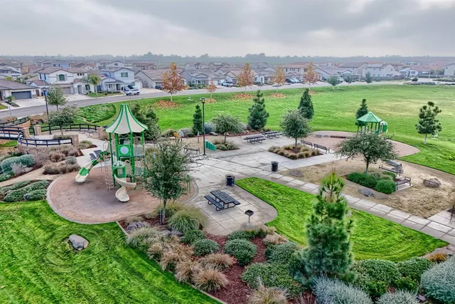 an aerial view of a residential houses with outdoor space and street view