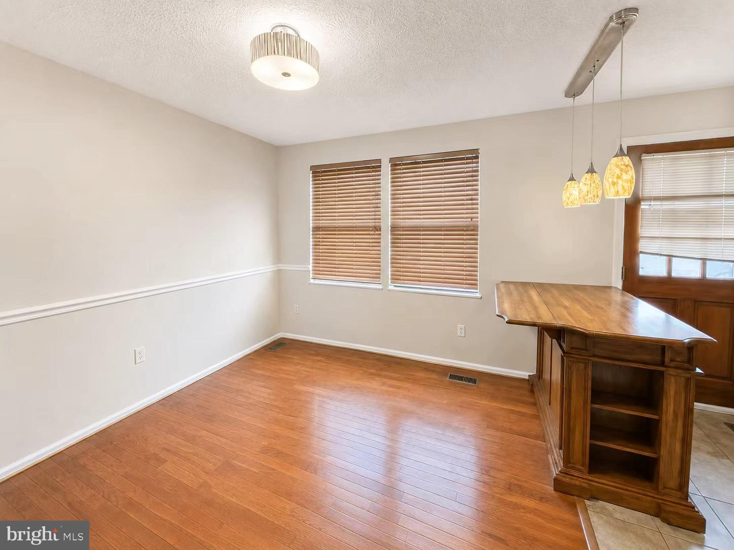 13336 Burkitts Road Fairfax, VA 22033 - Photo 4 of 14 an empty room with wooden floor cabinet and windows