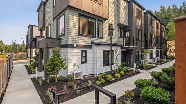 a view of brick house with potted plants and a bench