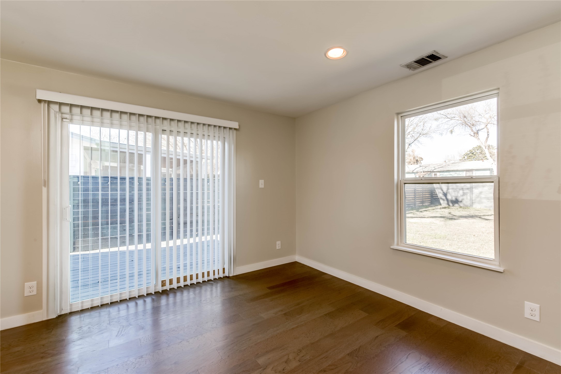 4702 Bandera Road Austin, TX 78721 - Photo 4 of 12 a view of an empty room with wooden floor and a window