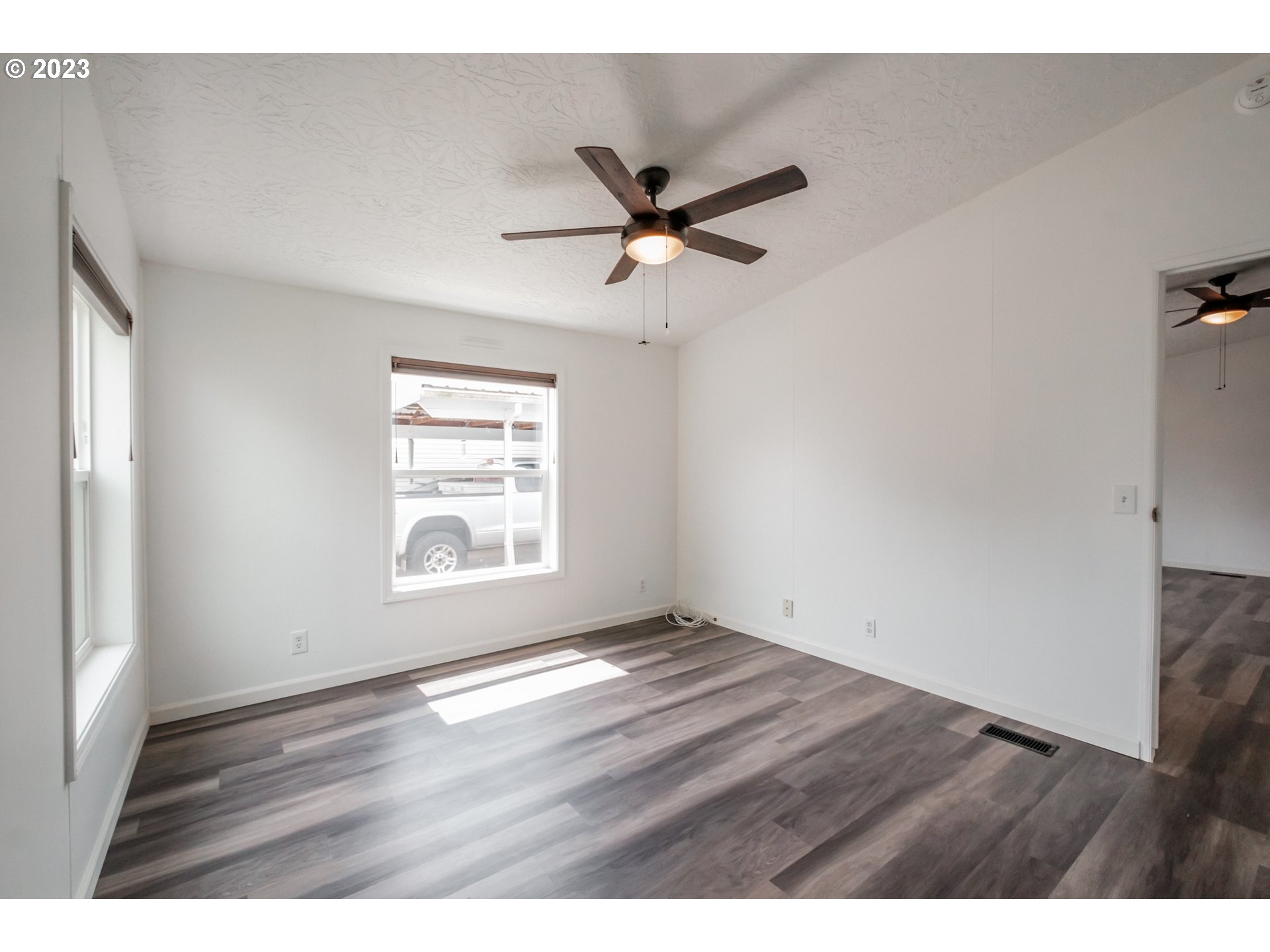 1401 West Ellendale Avenue, Unit 80 Dallas, OR 97338 - Photo 23 of 48 a view of an empty room with wooden floor and a window
