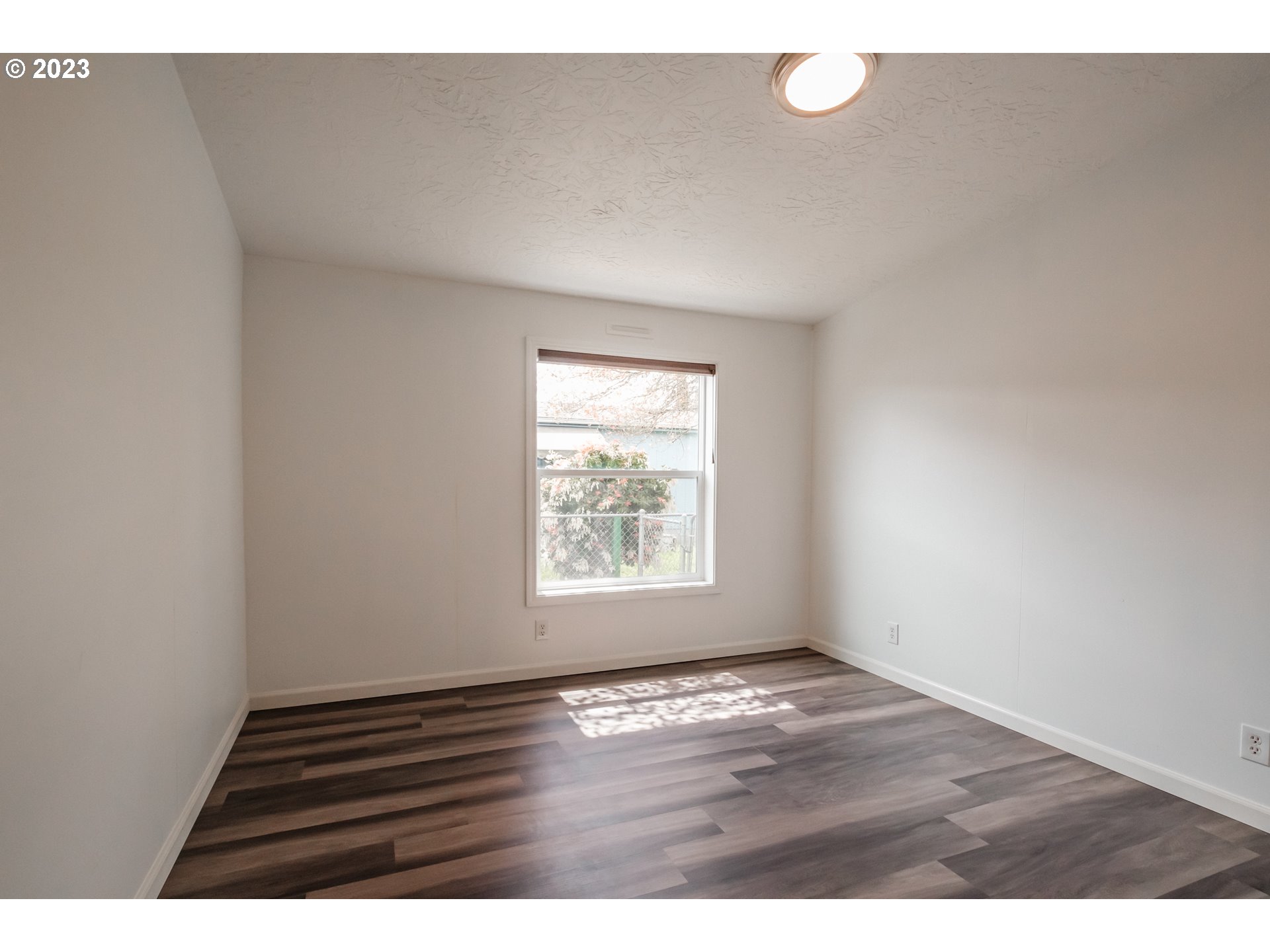 1401 West Ellendale Avenue, Unit 80 Dallas, OR 97338 - Photo 30 of 48 a view of an empty room with wooden floor and a window