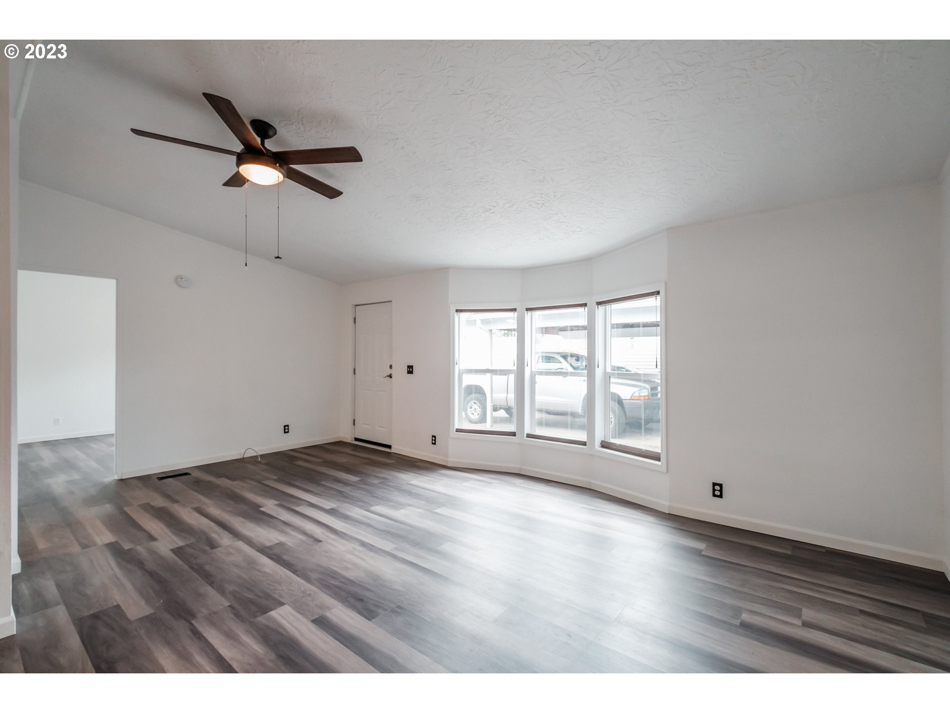 1401 West Ellendale Avenue, Unit 80 Dallas, OR 97338 - Photo 7 of 48 a view of empty room with wooden floor and fan