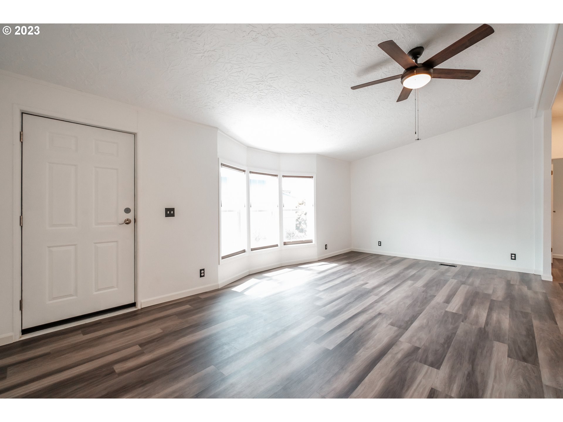 1401 West Ellendale Avenue, Unit 80 Dallas, OR 97338 - Photo 8 of 48 an empty room with wooden floor and windows