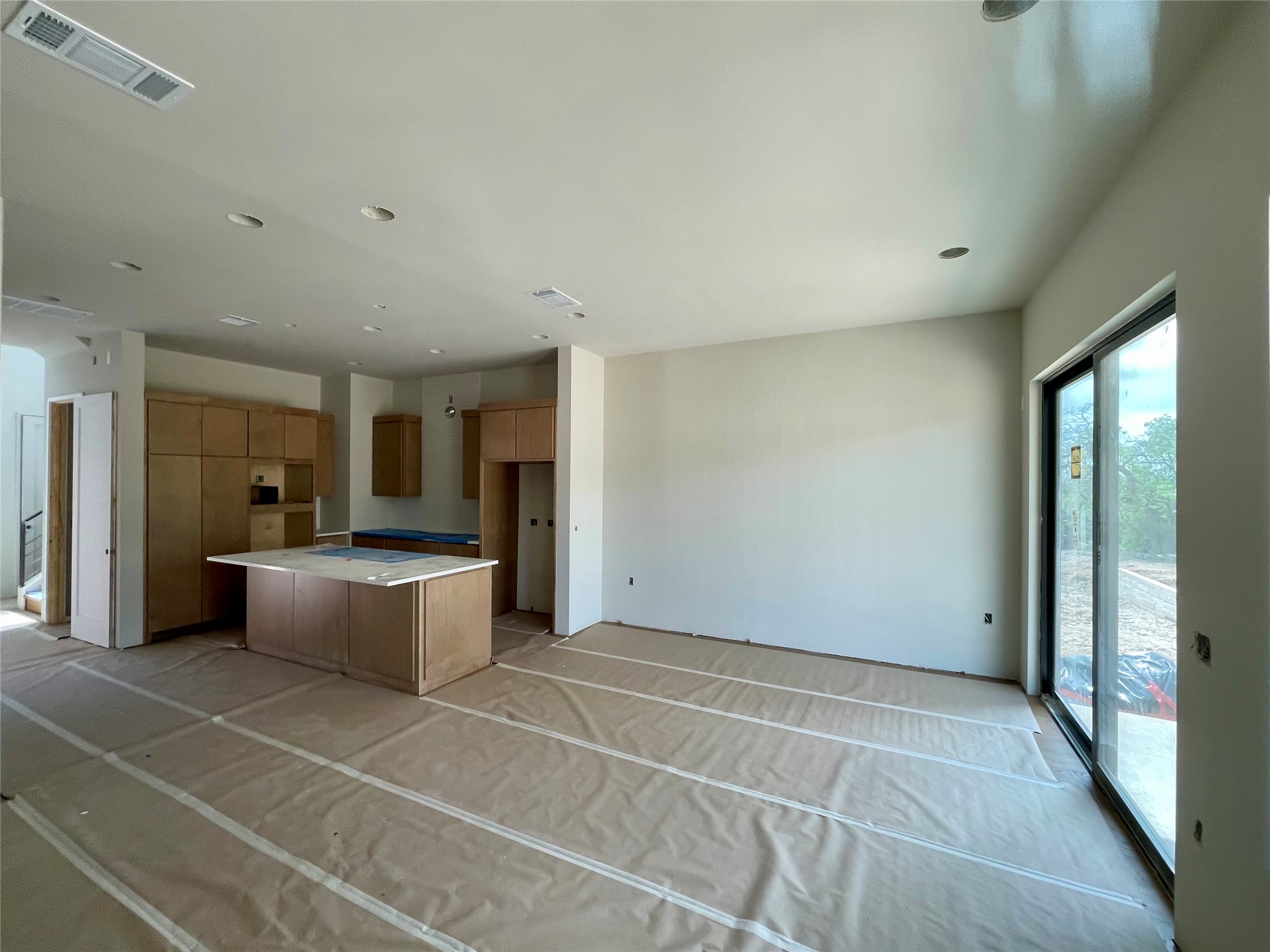 9803 Ribelin Ranch Court, Unit 21 Austin, TX 78750 - Photo 10 of 20 Expansive open concept living area featuring recessed lighting, a modern kitchen island, and sliding glass doors that open to an outdoor area