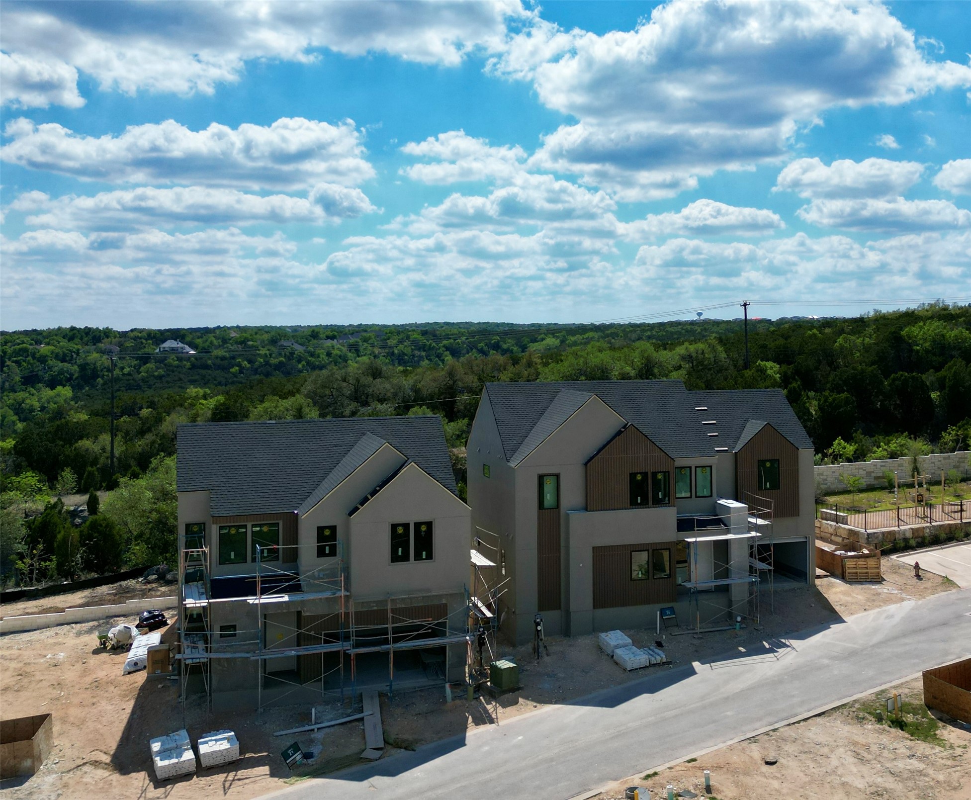 9803 Ribelin Ranch Court, Unit 21 Austin, TX 78750 - Photo 4 of 20 The property features a dark gray shingle roof and a light beige exterior, with dark brown accent panels