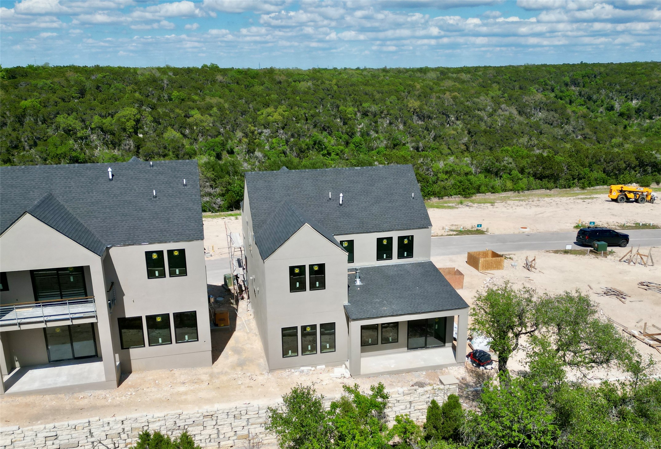 9803 Ribelin Ranch Court, Unit 21 Austin, TX 78750 - Photo 7 of 20 The property features a dark gray shingled roof, light-colored exterior walls, and multiple windows with dark frames