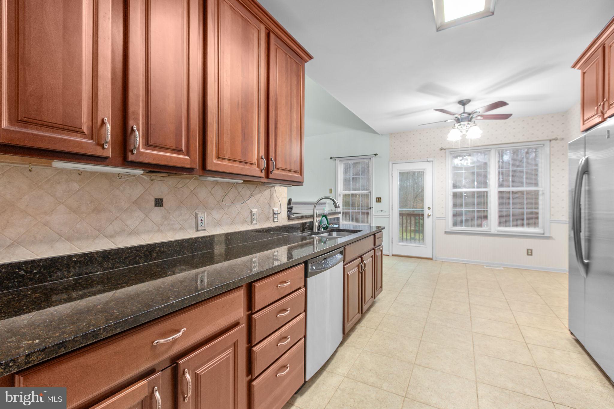 10721 Colbys Lane King George, VA 22485 - Photo 11 of 50 a large kitchen with granite countertop a stove a sink dishwasher and a microwave oven