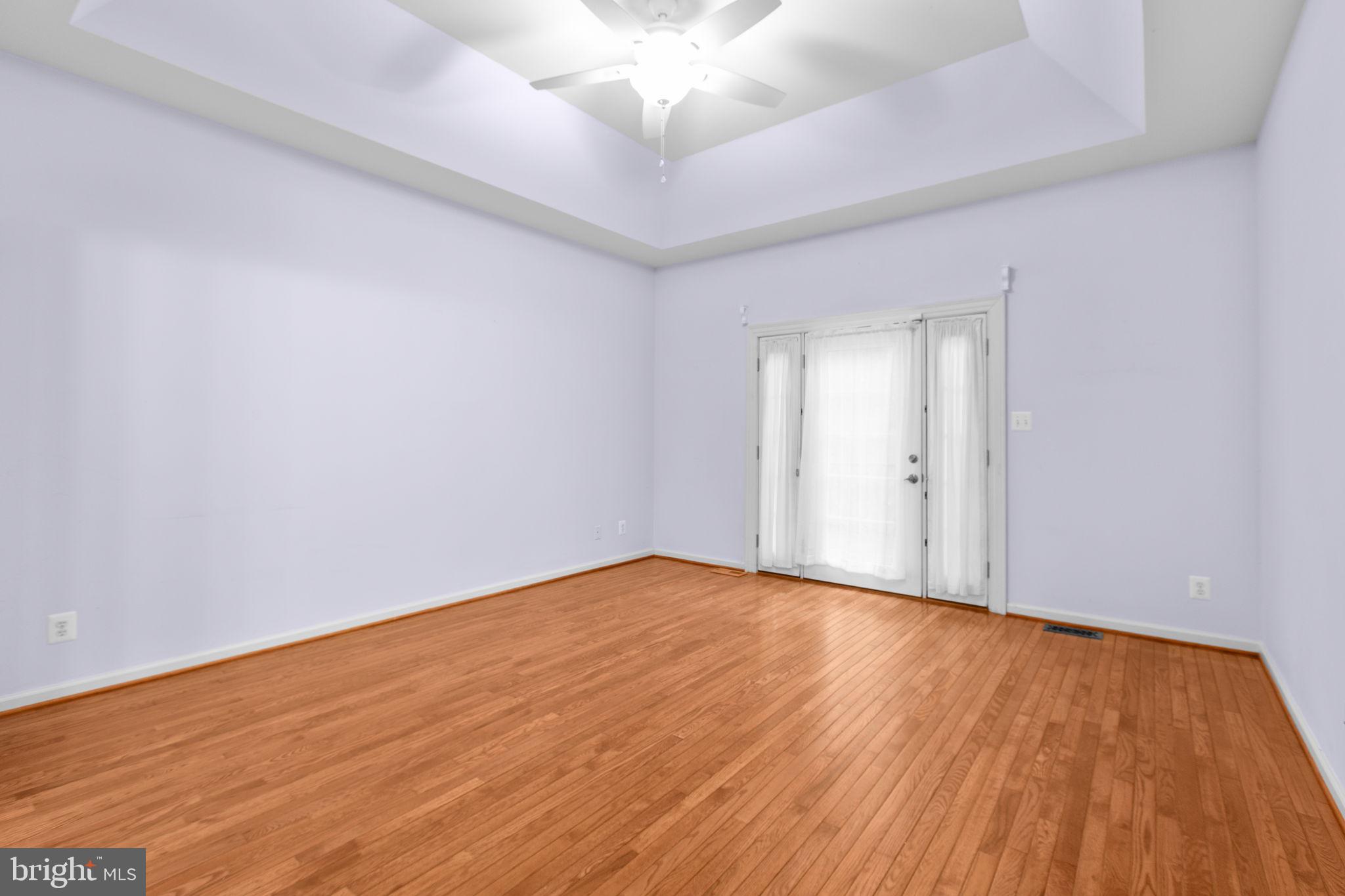 10721 Colbys Lane King George, VA 22485 - Photo 19 of 50 a view of an empty room with wooden floor and a ceiling fan