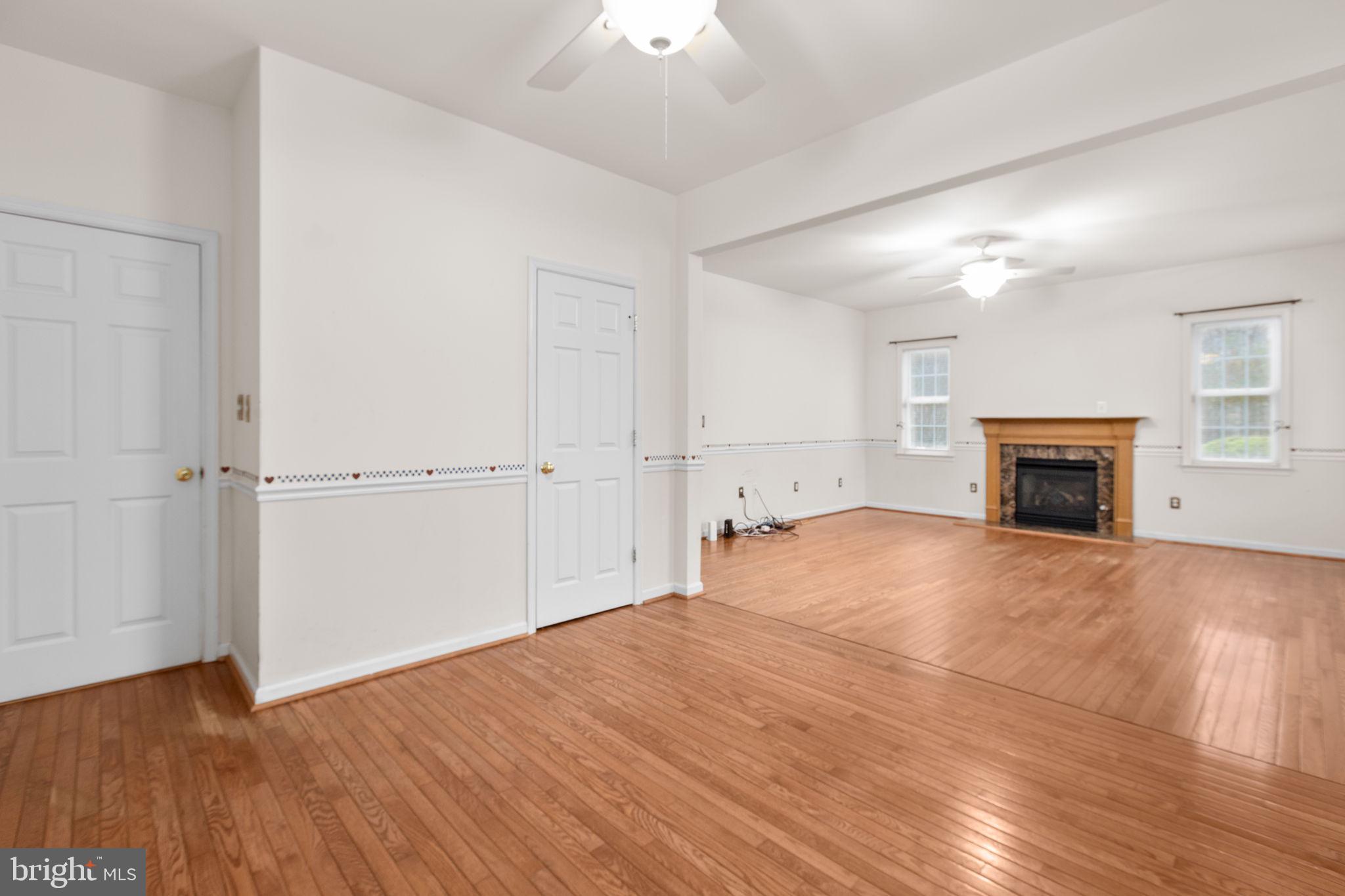10721 Colbys Lane King George, VA 22485 - Photo 28 of 50 an empty room with wooden floor fireplace and windows