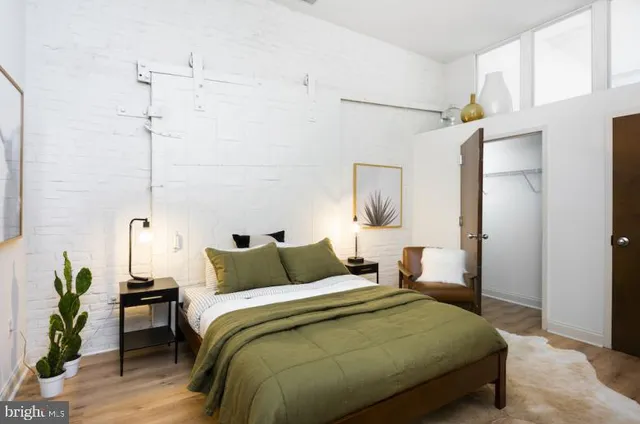 a bedroom with a bed and a potted plant