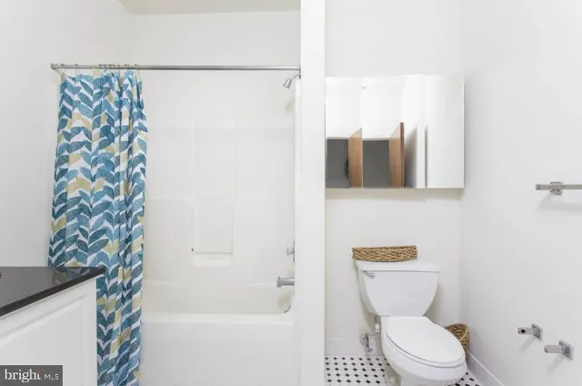a white toilet sitting next to a bath tub