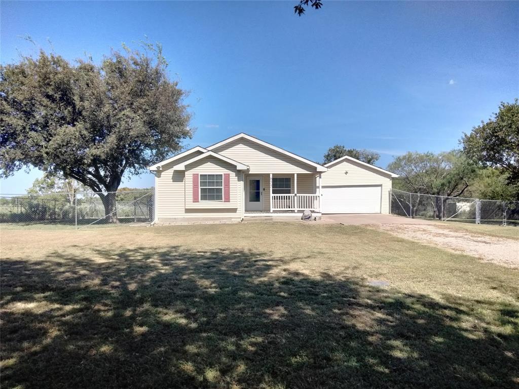 a view of house with backyard and tree