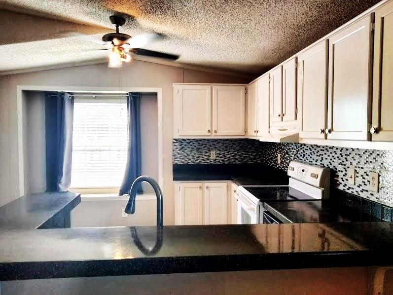 855 Tom Sawyer Road Ennis, TX 75119 - Photo 14 of 17 a kitchen with stainless steel appliances granite countertop a sink a stove and a granite counter tops with a large window