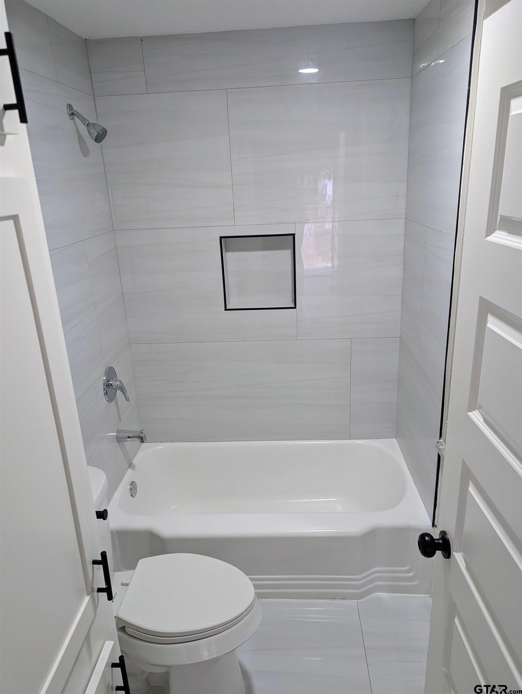 1213 Academy Street Tyler, TX 75701 - Photo 11 of 41 a white bath tub sitting next to a toilet