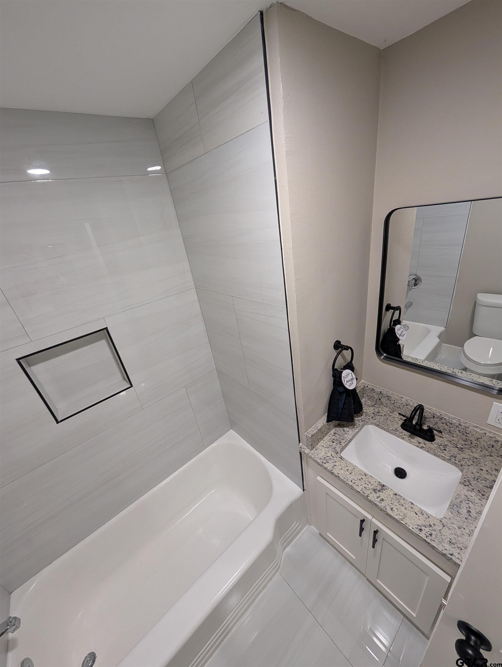 1213 Academy Street Tyler, TX 75701 - Photo 13 of 41 a bathroom with a sink and a bathtub