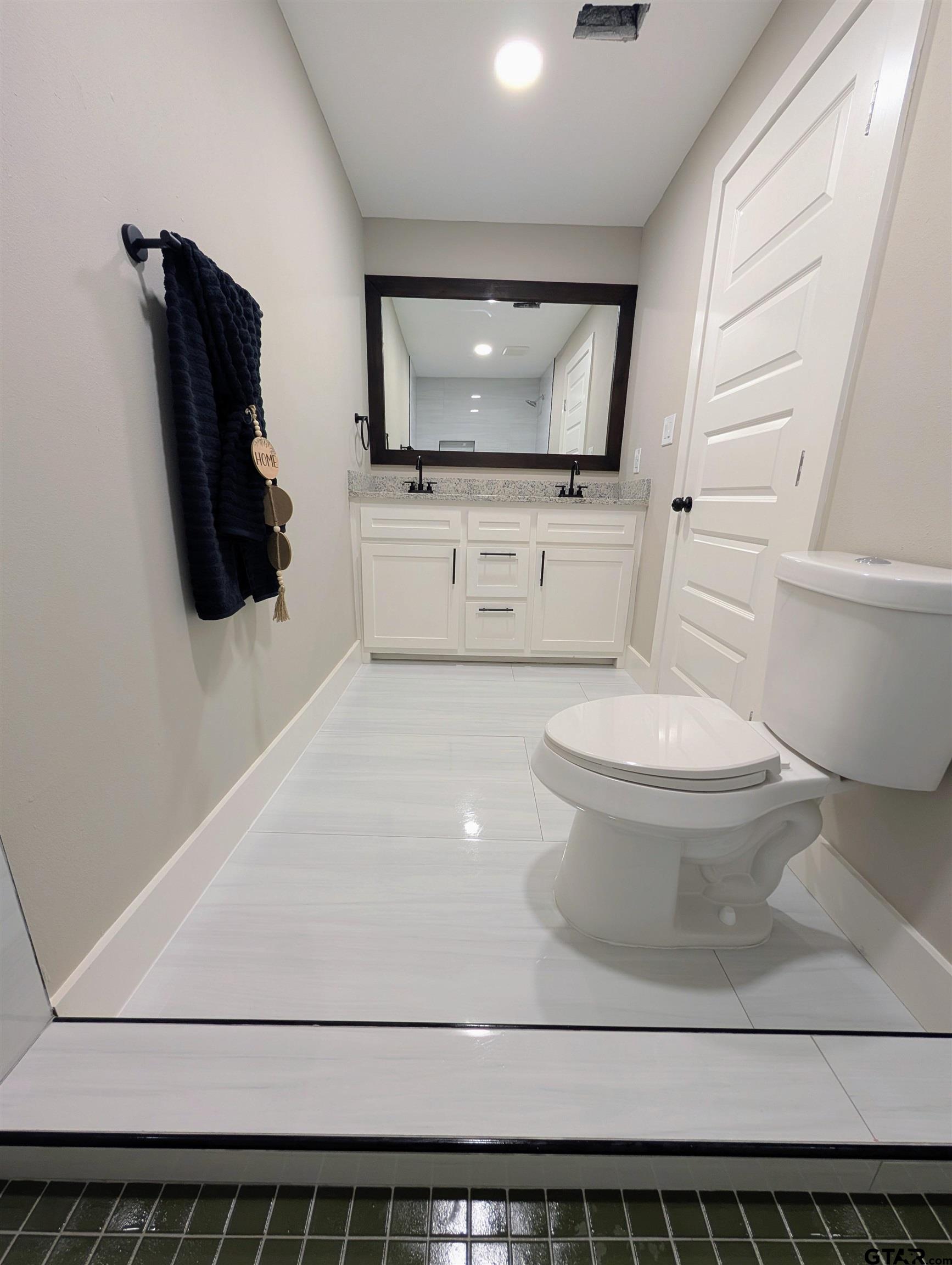 1213 Academy Street Tyler, TX 75701 - Photo 21 of 41 a bathroom with a toilet a sink and mirror