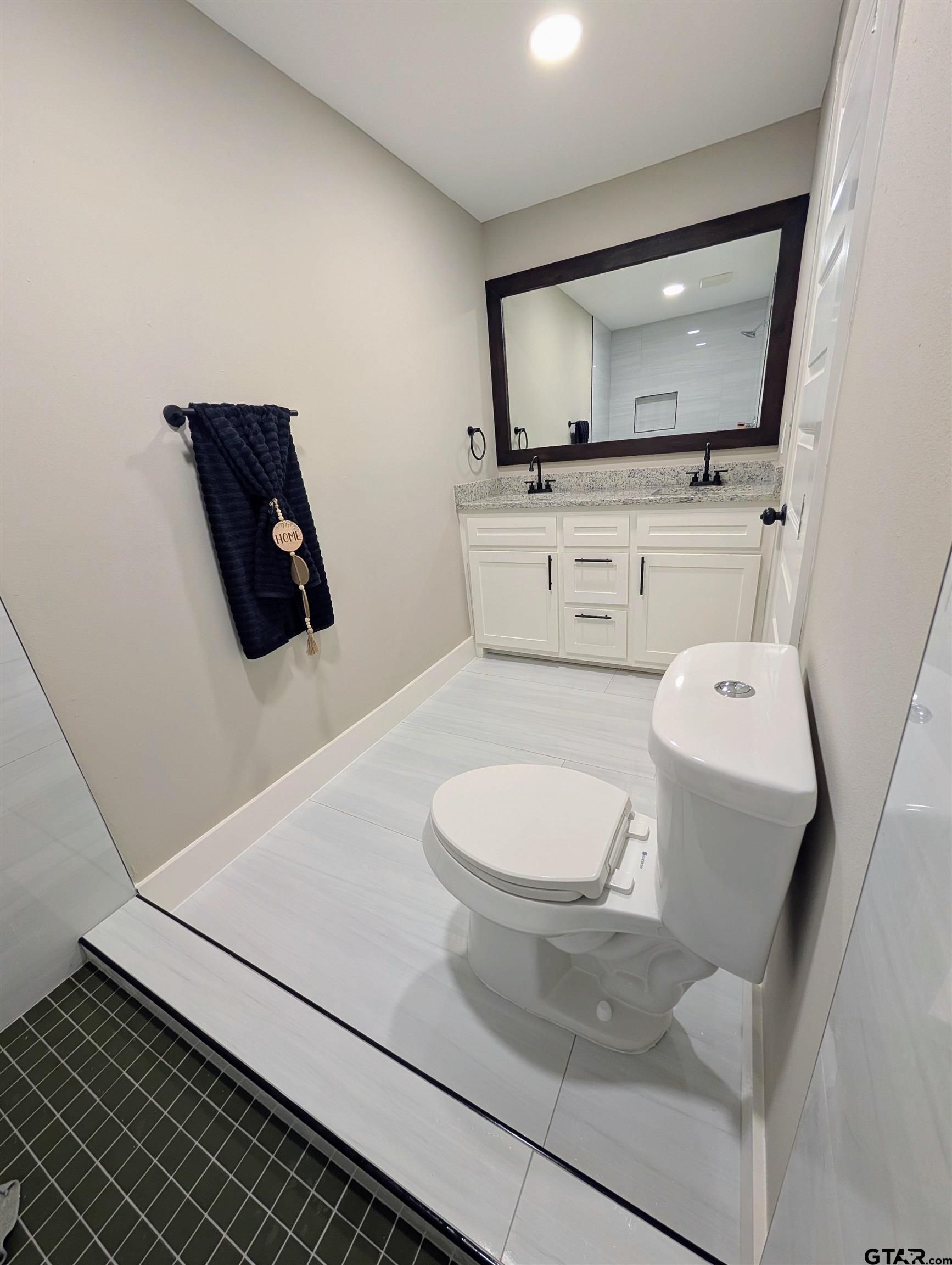 1213 Academy Street Tyler, TX 75701 - Photo 22 of 41 a bathroom with a toilet a sink and mirror