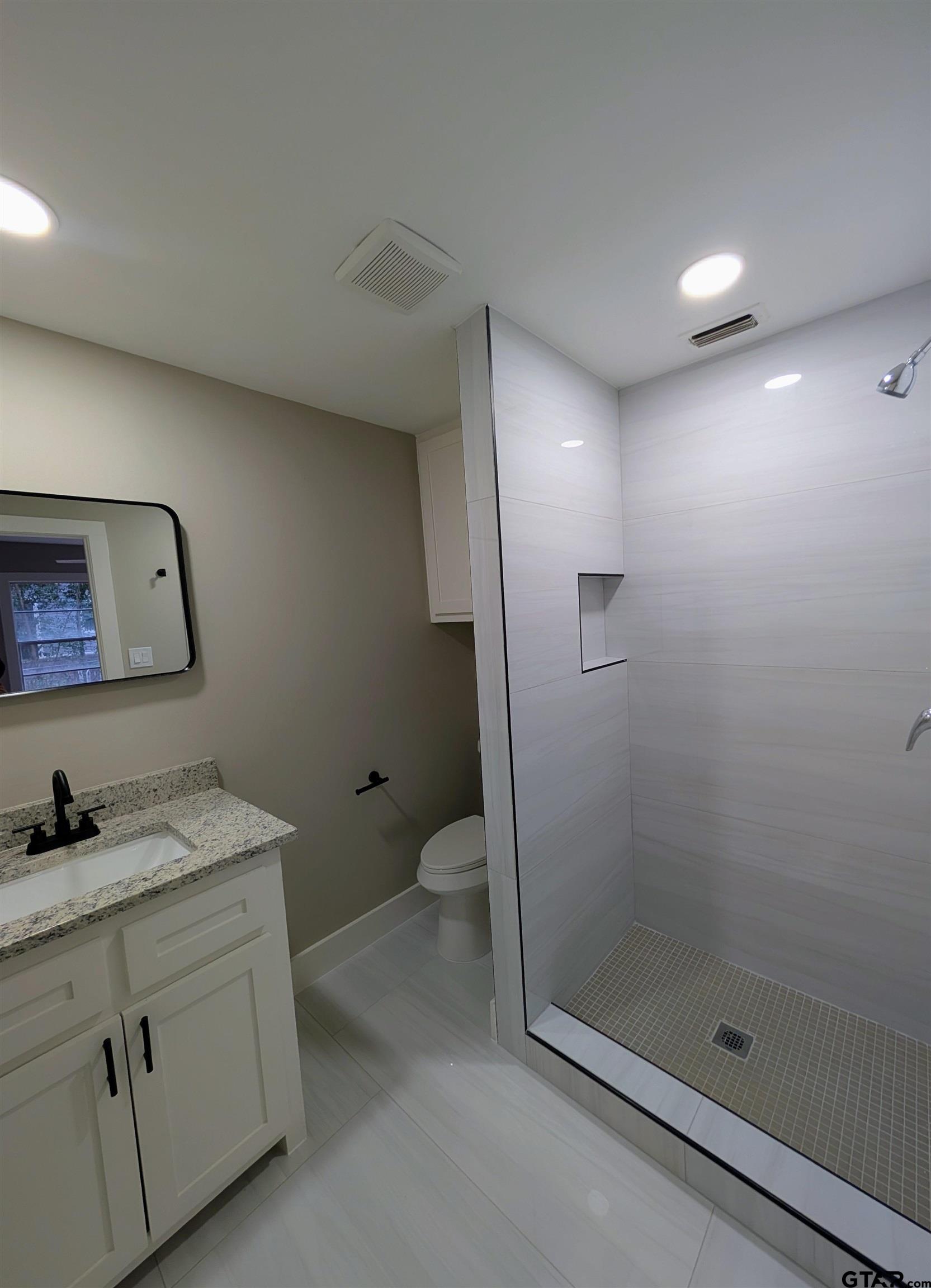 1213 Academy Street Tyler, TX 75701 - Photo 26 of 41 a bathroom with a granite countertop sink mirror vanity and toilet