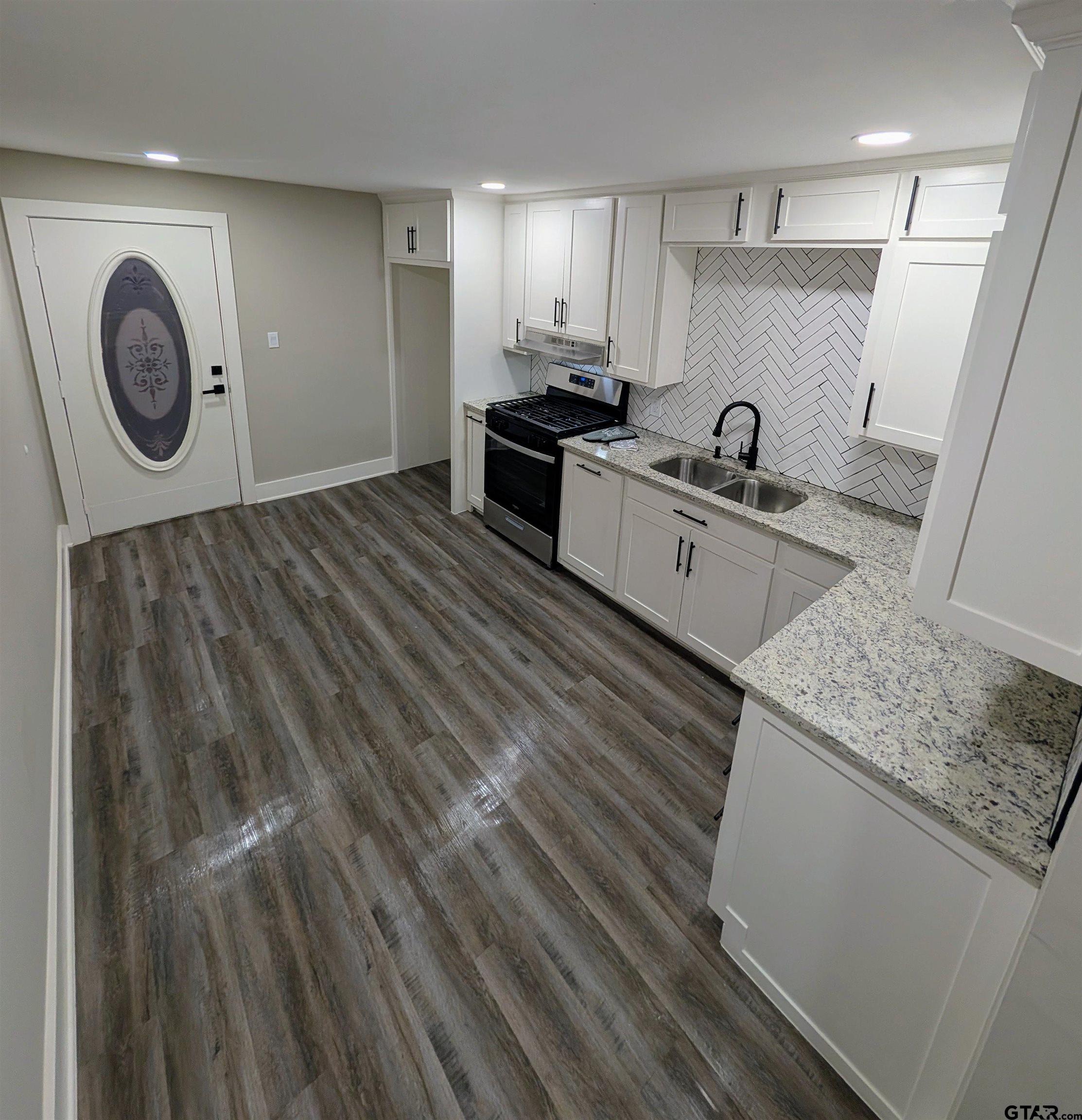1213 Academy Street Tyler, TX 75701 - Photo 4 of 41 a kitchen with a refrigerator and a stove top oven