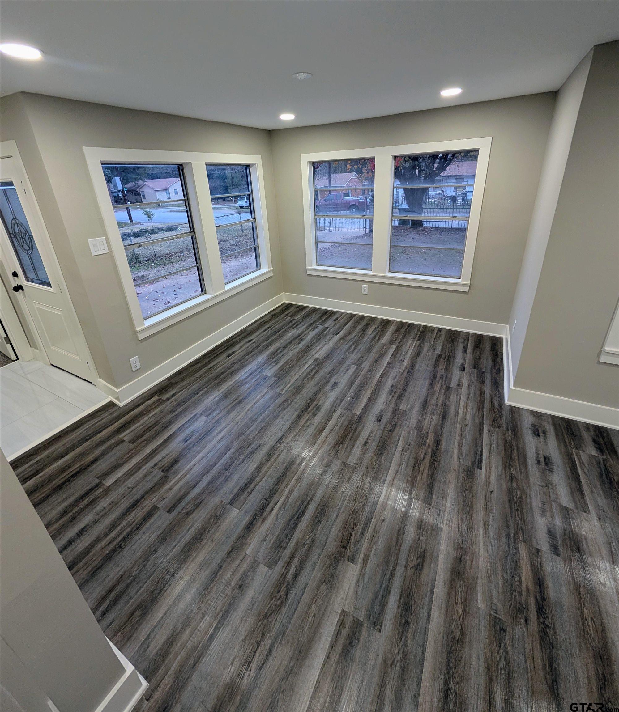 1213 Academy Street Tyler, TX 75701 - Photo 9 of 41 a view of an empty room with wooden floor and workspace