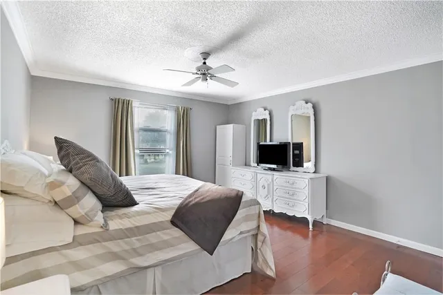 a living room with a bed furniture and a flat screen tv