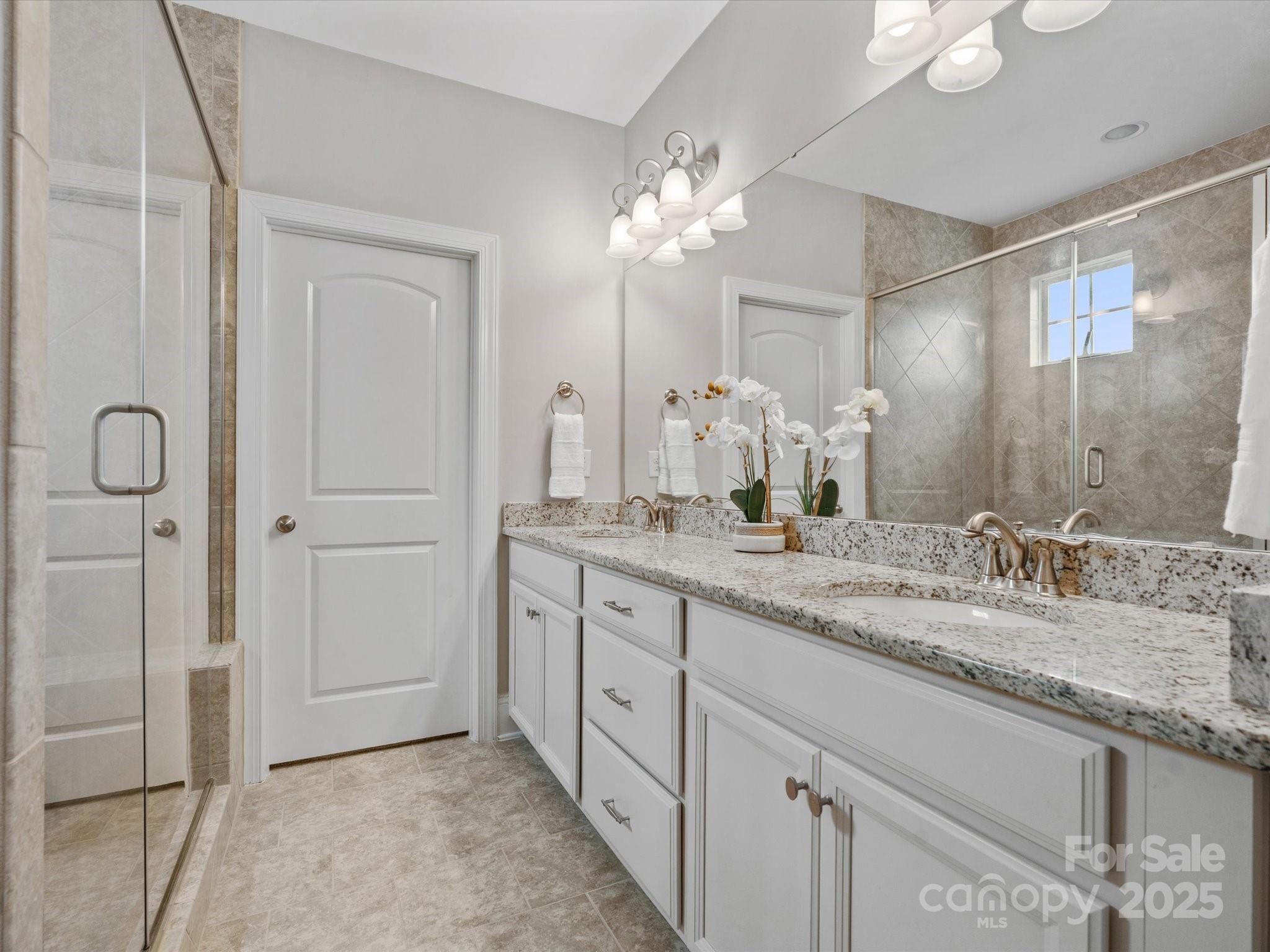 130 Villa Lake Drive Fort Mill, SC 29708 - Photo 18 of 46 a spacious bathroom with a granite countertop sink a mirror and a shower