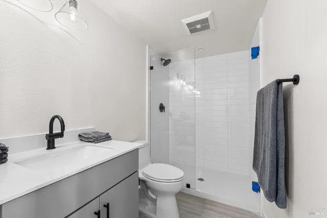 a bathroom with a sink a toilet and shower