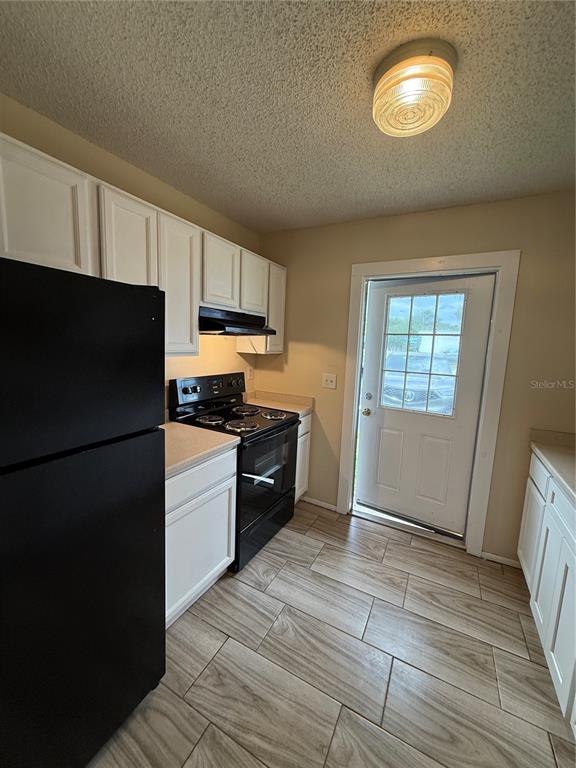 2744 Botts Landing Road, Unit 603 DeLand, FL 32720 - Photo 12 of 17 a kitchen with stainless steel appliances granite countertop a refrigerator a stove a sink and a microwave