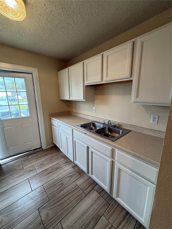 2744 Botts Landing Road, Unit 603 DeLand, FL 32720 - Photo 13 of 17 a kitchen with granite countertop a sink stove and cabinets