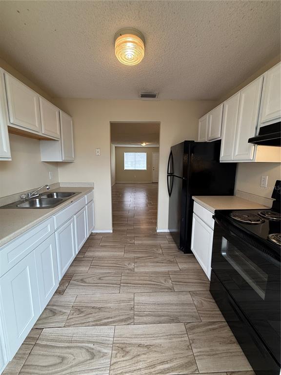 2744 Botts Landing Road, Unit 603 DeLand, FL 32720 - Photo 14 of 17 a kitchen with a stove and a refrigerator