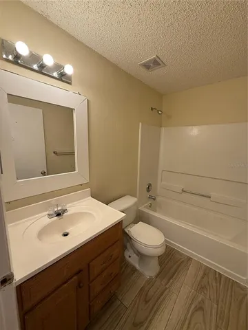 a bathroom with a sink a toilet a mirror and shower