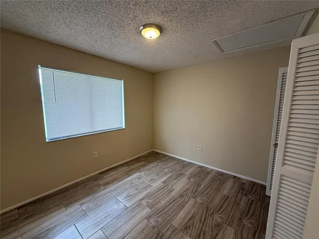 a view of empty room with wooden floor