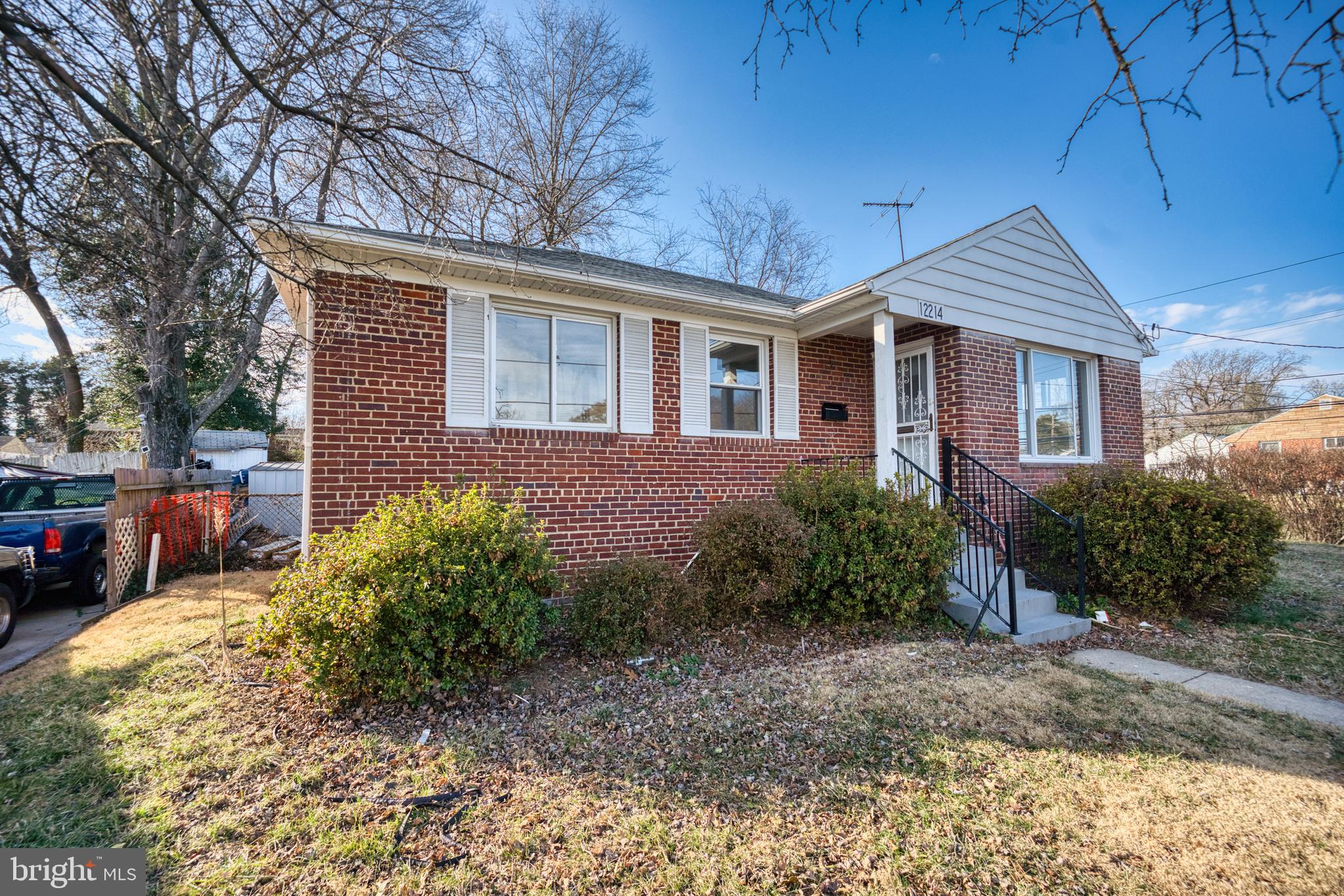 12214 Connecticut Avenue Silver Spring, MD 20902 - Photo 16 of 18 a view of a brick house next to a yard with plants and trees