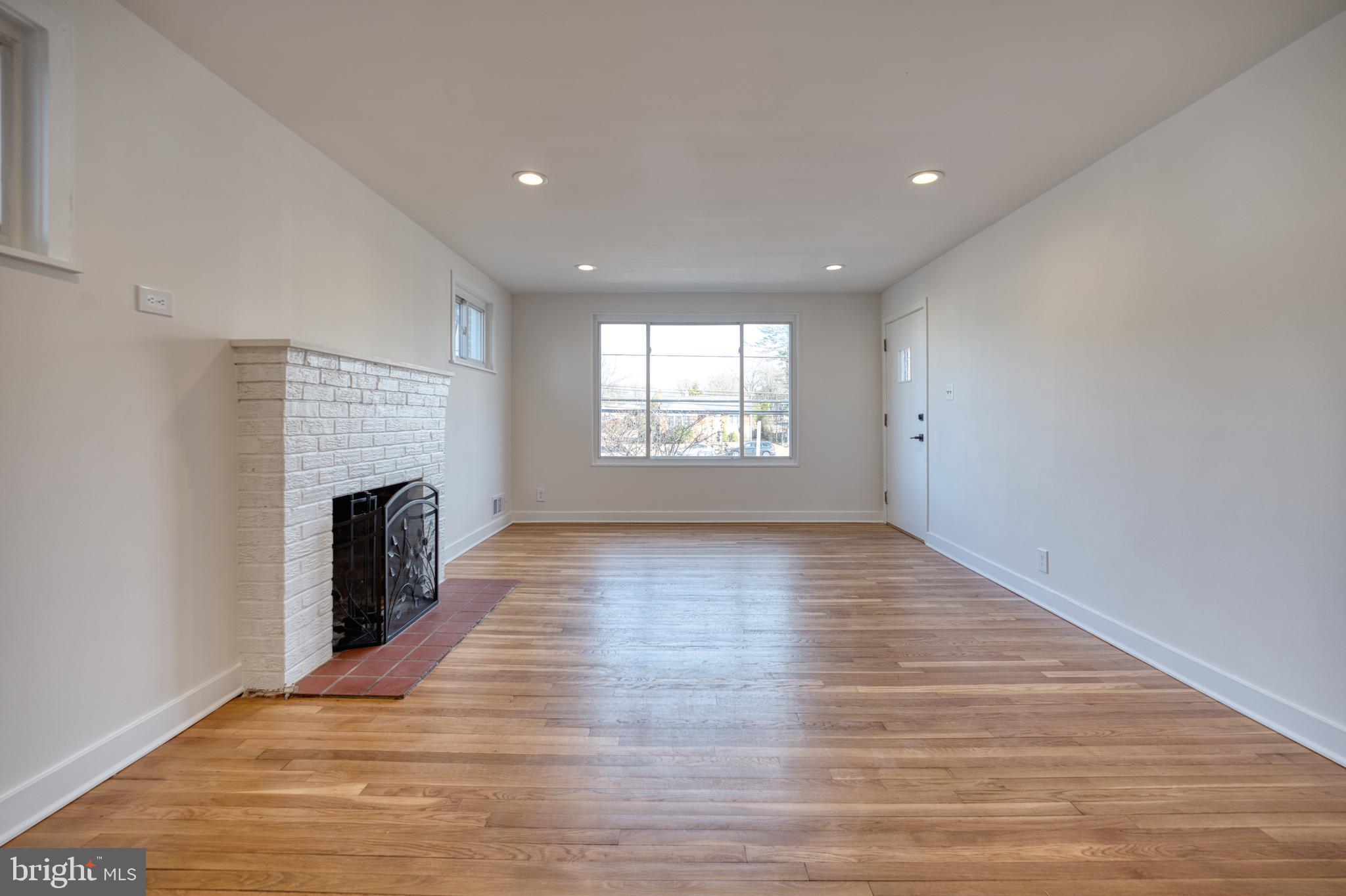 12214 Connecticut Avenue Silver Spring, MD 20902 - Photo 3 of 18 a view of empty room with wooden floor and fireplace