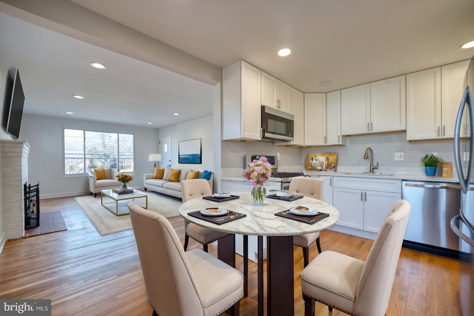 12214 Connecticut Avenue Silver Spring, MD 20902 - Photo 4 of 18 a kitchen with stainless steel appliances kitchen island granite countertop a sink a stove a dining table and chairs with wooden floor