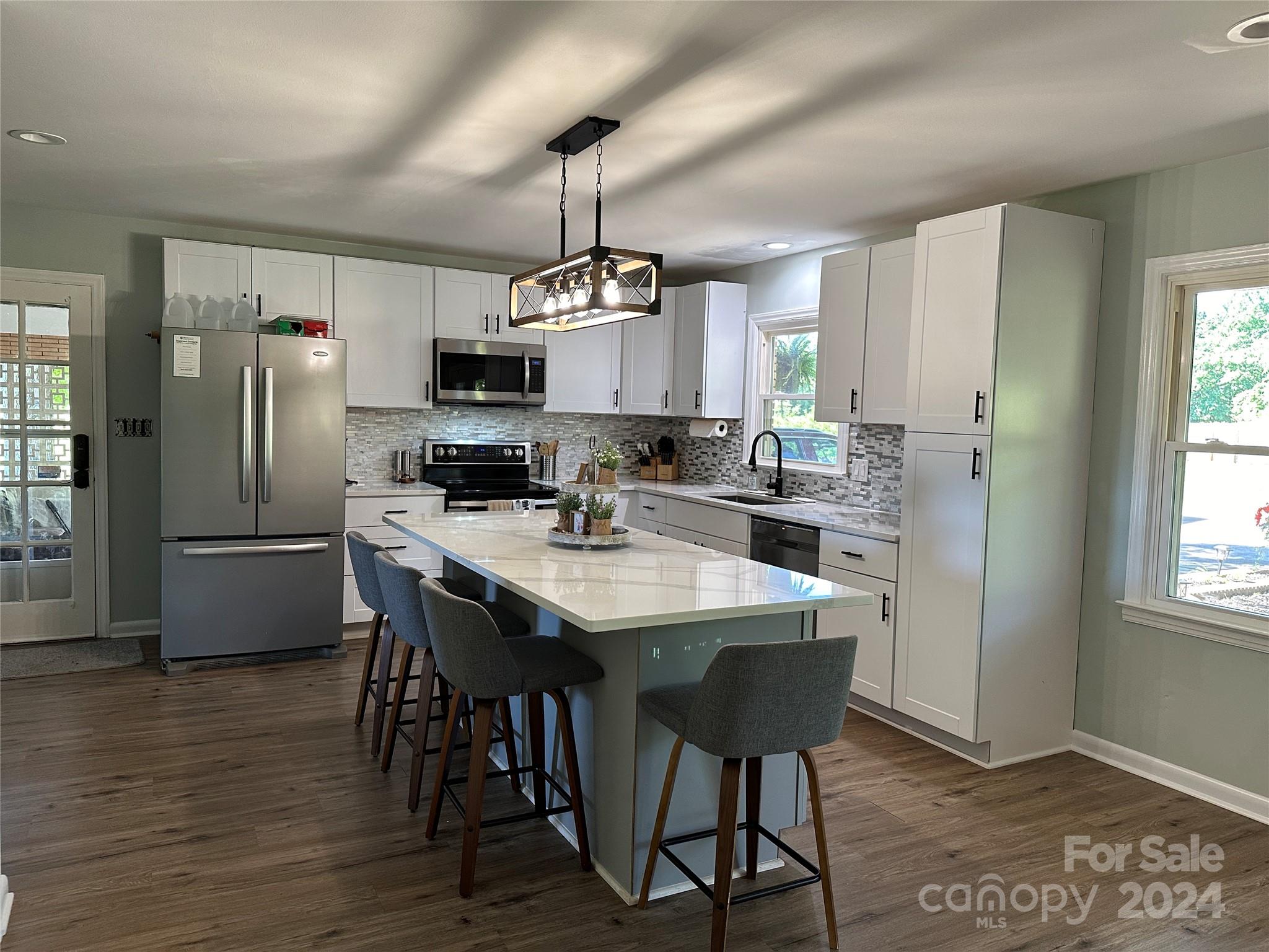 1118 Stack Road Monroe, NC 28112 - Photo 12 of 42 a kitchen with stainless steel appliances granite countertop a dining table chairs refrigerator and sink
