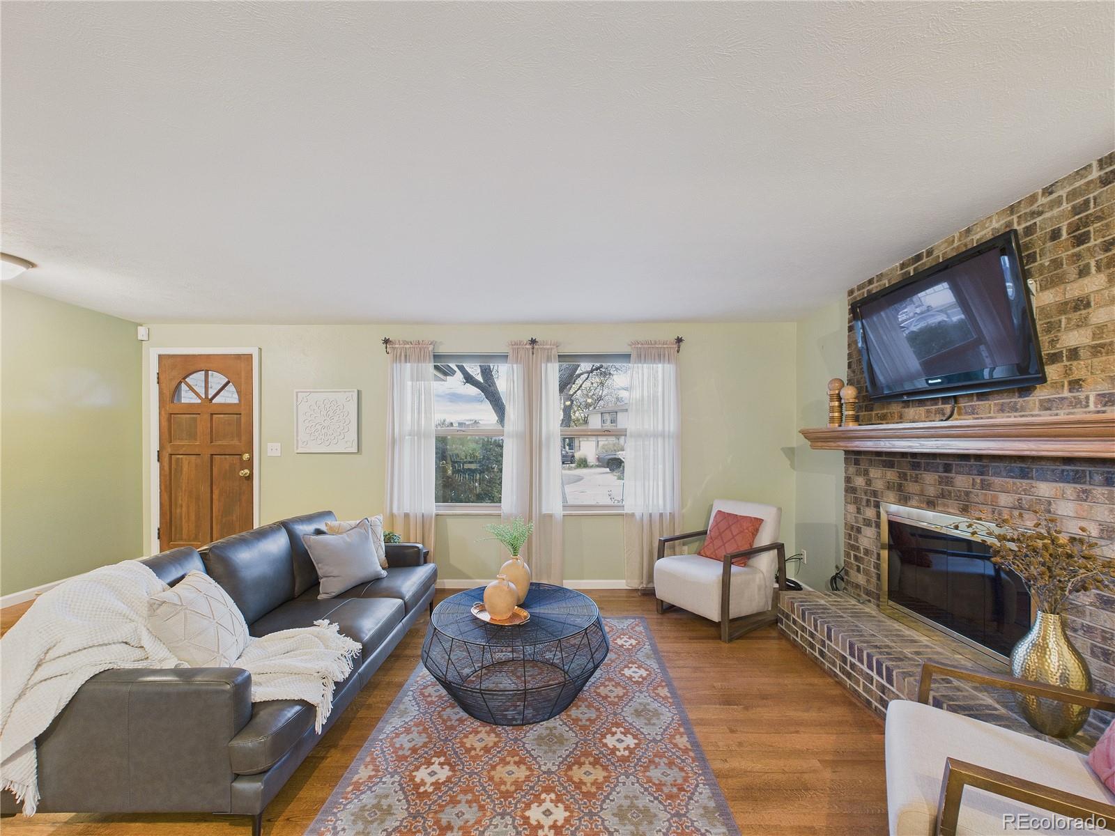 8373 Zephyr Street Arvada, CO 80005 - Photo 15 of 31 a living room with furniture large window and a fireplace