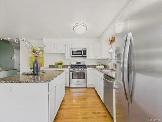 a bathroom with a granite countertop sink a mirror and a shower