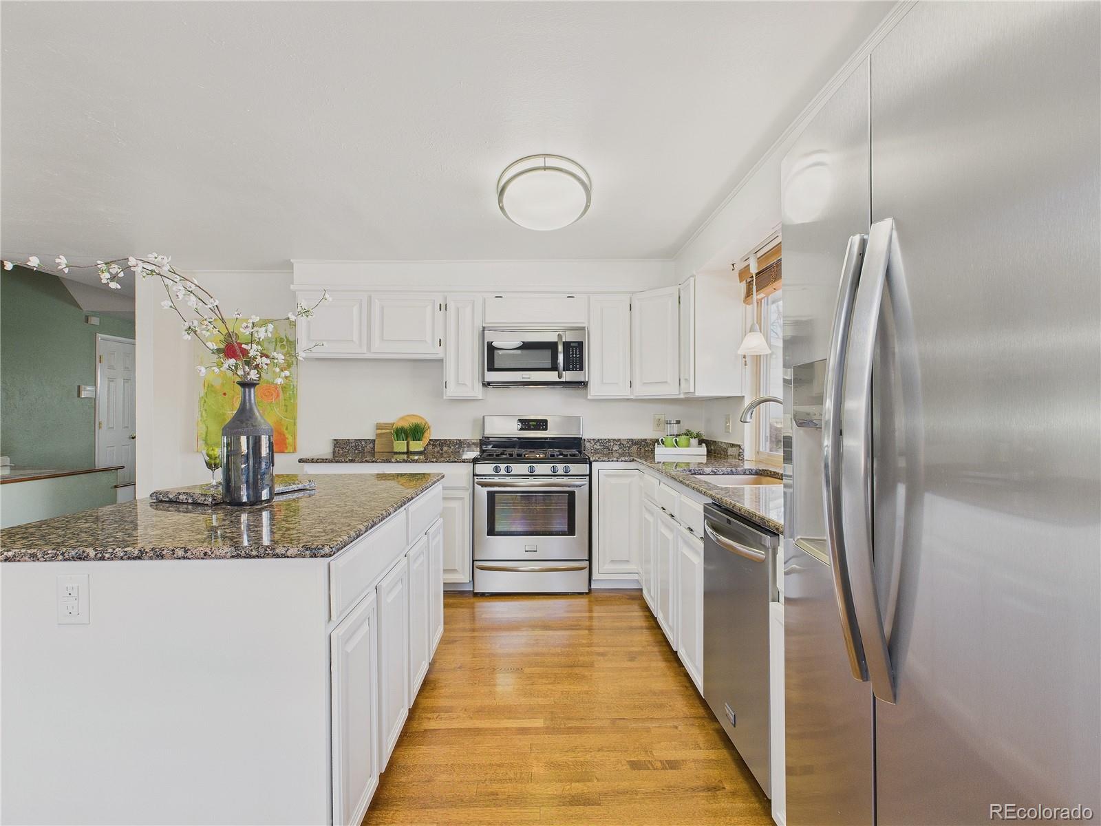 8373 Zephyr Street Arvada, CO 80005 - Photo 17 of 31 a large kitchen with cabinets stainless steel appliances and a counter space