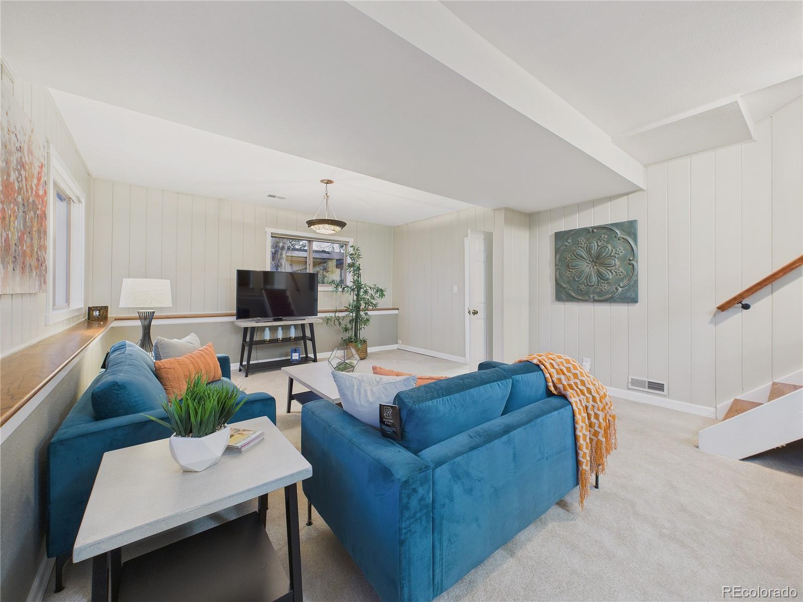 8373 Zephyr Street Arvada, CO 80005 - Photo 19 of 31 a living room with furniture and a flat screen tv