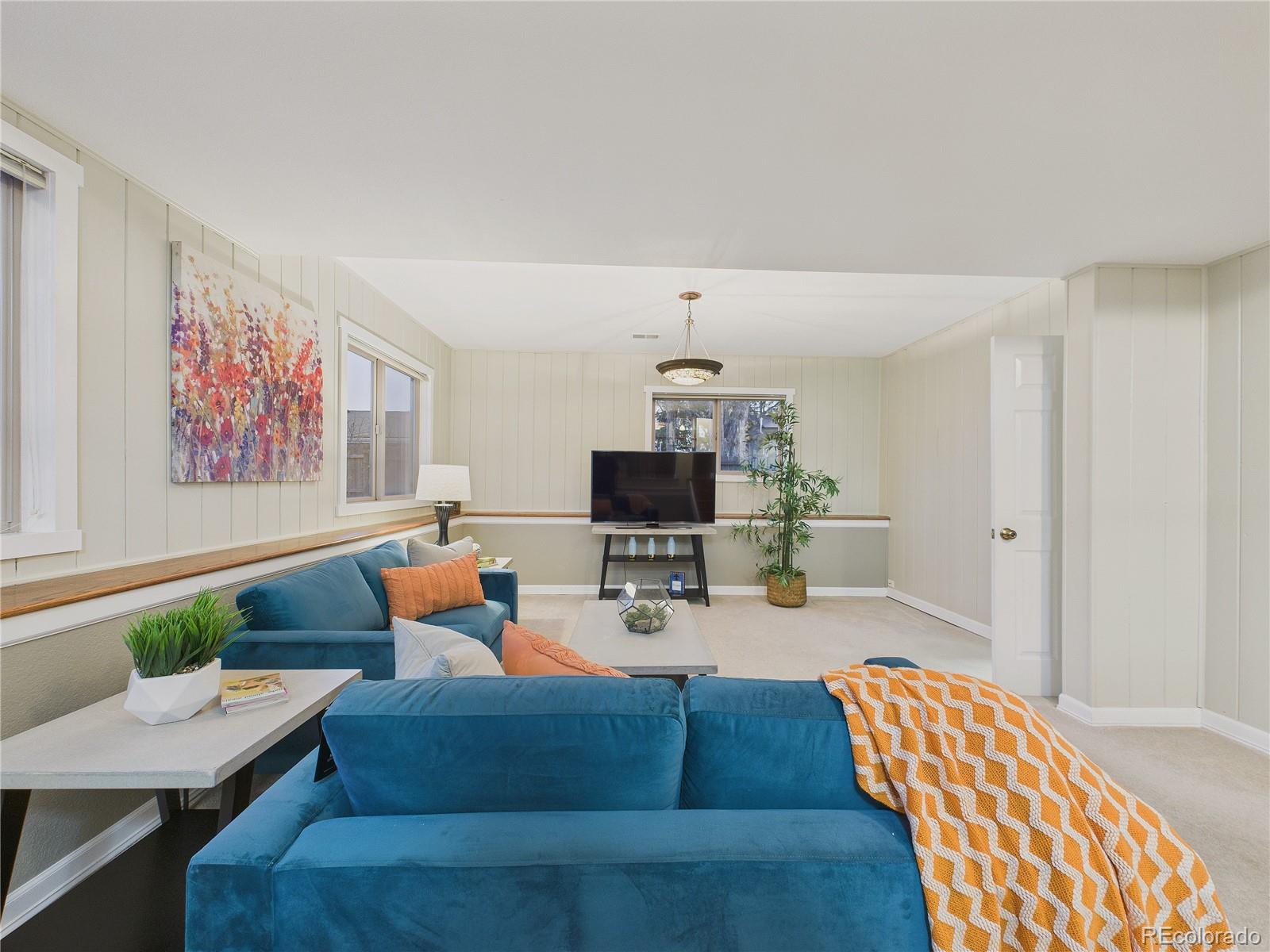 8373 Zephyr Street Arvada, CO 80005 - Photo 20 of 31 a living room with furniture and a flat screen tv