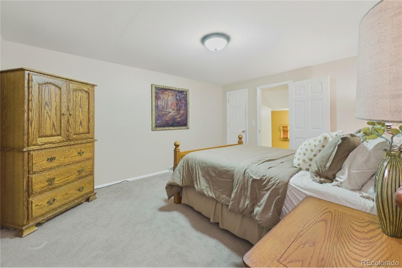8373 Zephyr Street Arvada, CO 80005 - Photo 22 of 31 a spacious bedroom with a bed and cabinet