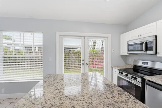 a kitchen with stainless steel appliances granite countertop a stove a sink and a refrigerator