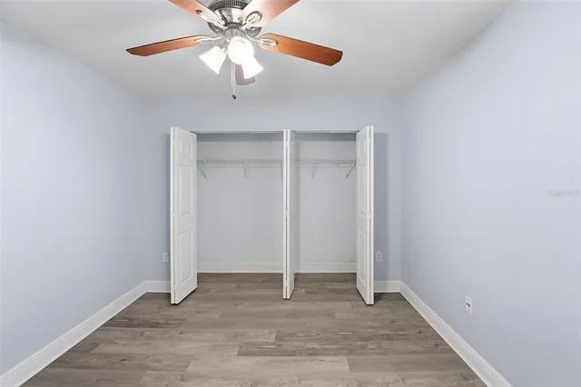 a view of an empty room with a chandelier fan