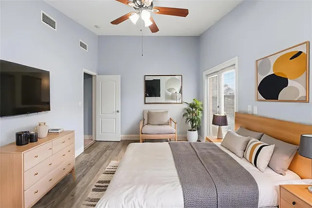 a bedroom with a large bed and a flat tv screen on dresser
