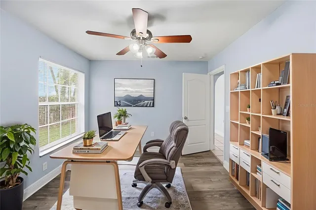 a view of a workspace with furniture and a window